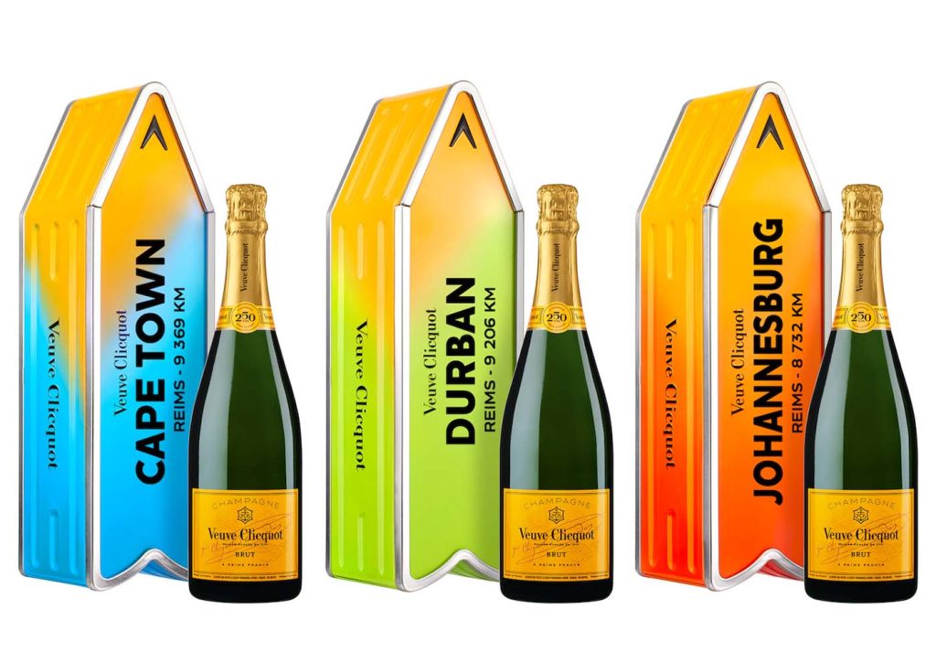 Veuve Clicquot Champagne bottles with colorful arrow casings indicating distances to Cape Town, Durban, and Johannesburg from Reims.