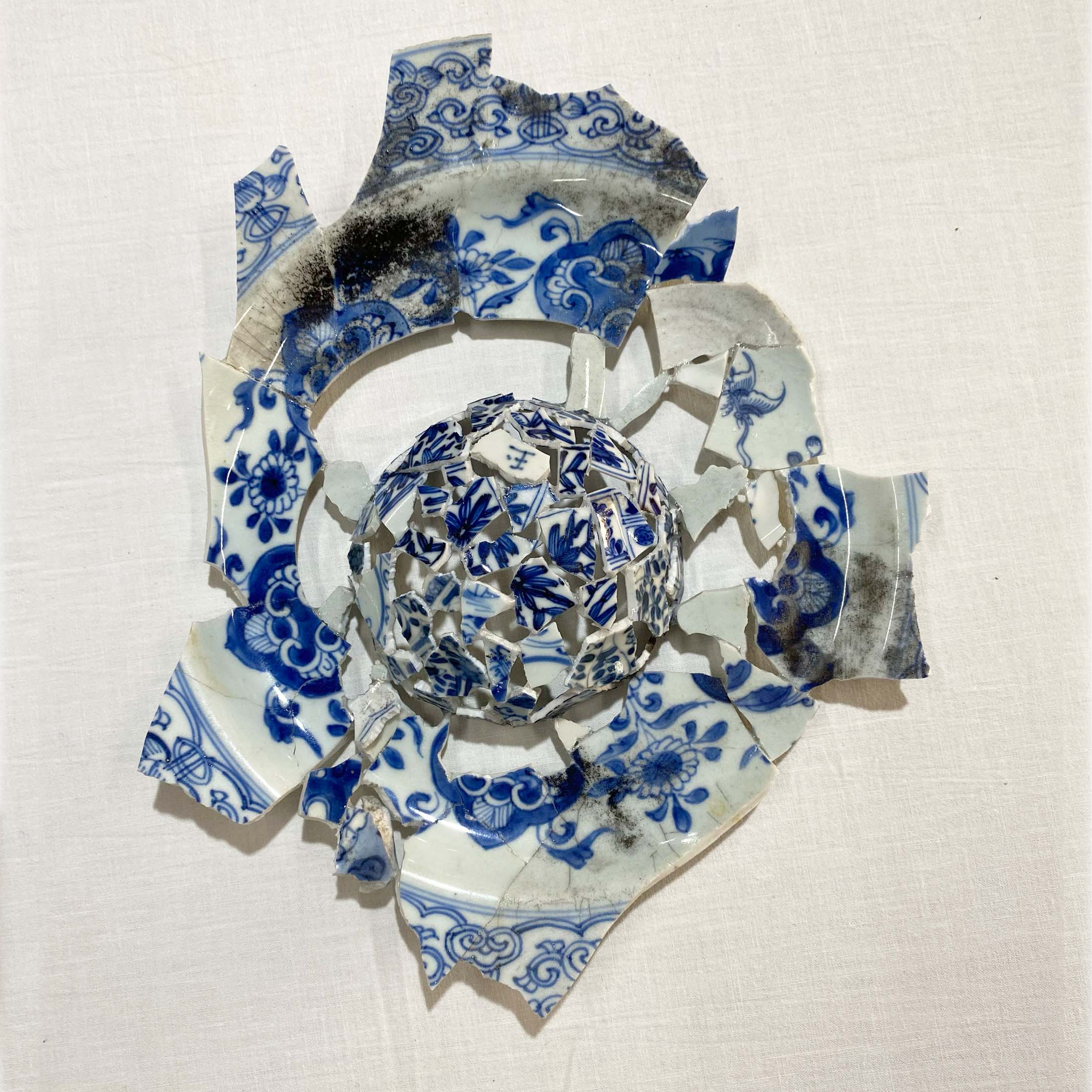 Mixed media piece 'Mirror Mirror' from Tamlin Blake's 'After the Fire' exhibition, composed of blue and white ceramic shards, inviting viewers to reflect on the craftsmanship in art and its enduring narrative."