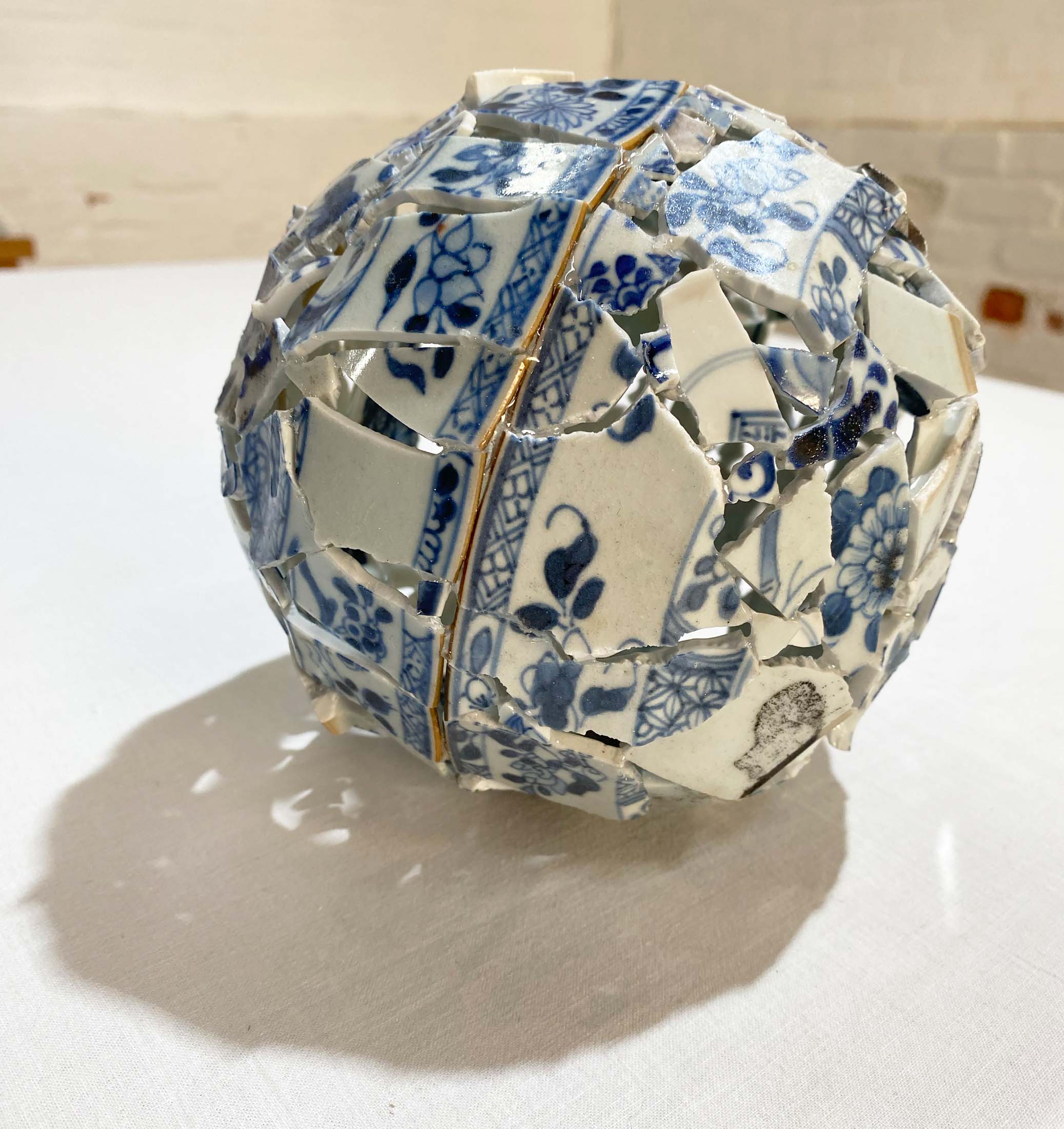A piece from Tamlin Blake's art show, 'Shard Bubble 2', featuring an intricate mosaic of china plate pieces, symbolizing the theme of art and resilience at the 'After the Fire' exhibition, Sisonke Gallery.