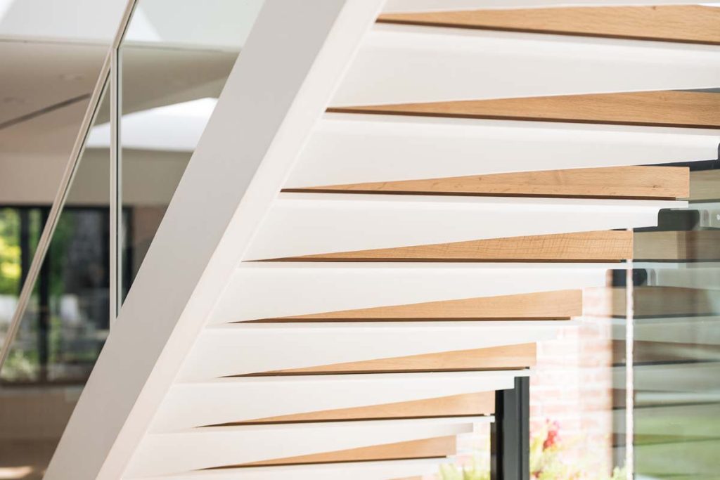 Detailed view of the modern wooden stair design in Dissonant House, showcasing the craftsmanship of the floating steps and the architectural rhythm created by the clean lines.