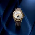 Styled image of the Frederique Constant Classics Moneta Moonphase in yellow gold PVD with a silver dial, black leather strap, and moonphase display.
