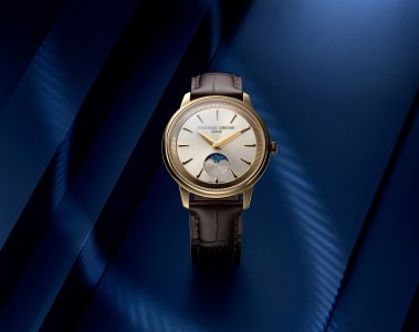 Styled image of the Frederique Constant Classics Moneta Moonphase in yellow gold PVD with a silver dial, black leather strap, and moonphase display.